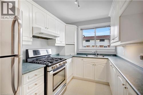 Kitchen featuring white cabinetry, stainless steel gas range, and a double basin sink - 32 Montclair Crescent, Simcoe, ON - Indoor Photo Showing Kitchen With Double Sink