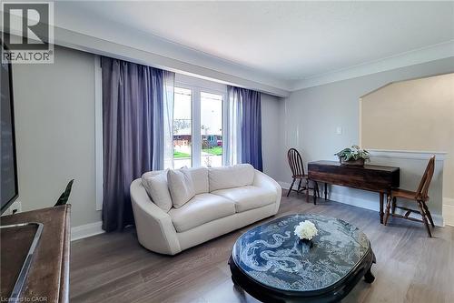 Spacious living area featuring light-toned walls, crown molding, and wood-finish flooring - 103 East 45Th Street, Hamilton, ON - Indoor Photo Showing Living Room