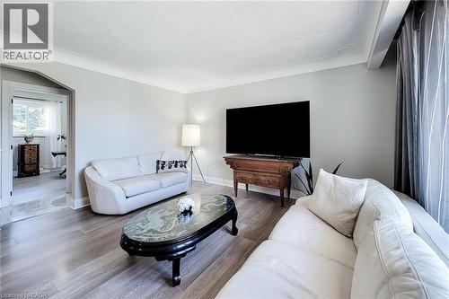 Light gray walls with crown molding, wood-finish flooring, recessed lighting, and an arched doorway - 103 East 45Th Street, Hamilton, ON - Indoor Photo Showing Living Room