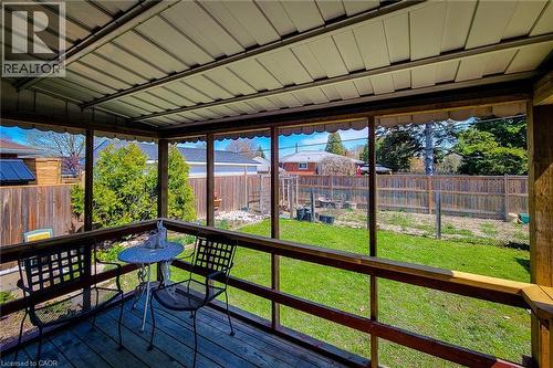 Screened-in porch featuring a wood deck, wood railings, and a metal paneled ceiling - 103 East 45Th Street, Hamilton, ON - Outdoor