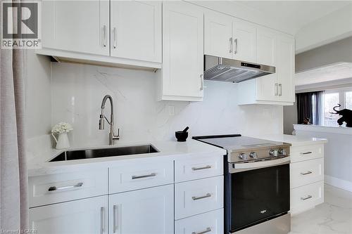 Contemporary kitchen with white shaker cabinetry, stainless steel appliances, a pull-down faucet, a single basin sink, and white countertops with a matching backsplash - 103 East 45Th Street, Hamilton, ON - Indoor Photo Showing Kitchen With Upgraded Kitchen