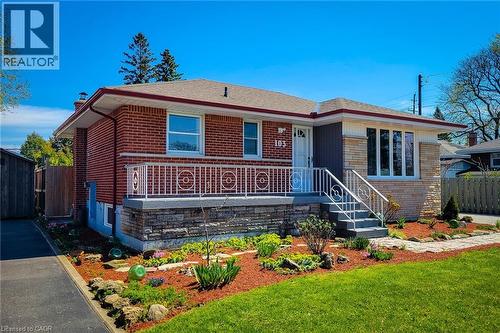 Brick and stone facade residence featuring a covered front porch with decorative railings - 103 East 45Th Street, Hamilton, ON - Outdoor With Deck Patio Veranda