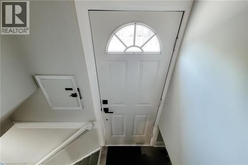 White paneled entry door with an arched transom window and black hardware - 103 East 45Th Street, Hamilton, ON - Indoor Photo Showing Other Room