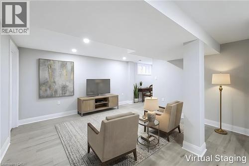Open-concept living area featuring light gray walls, wood-finish flooring, recessed lighting, and a structural column - 103 East 45Th Street, Hamilton, ON - Indoor Photo Showing Basement