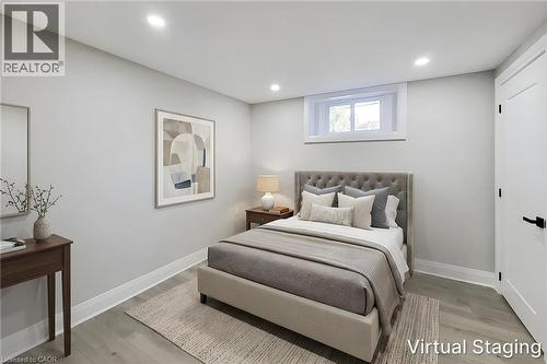 Wood-finish flooring with white baseboards, recessed lighting, and a white window frame with a single window - 103 East 45Th Street, Hamilton, ON - Indoor Photo Showing Bedroom