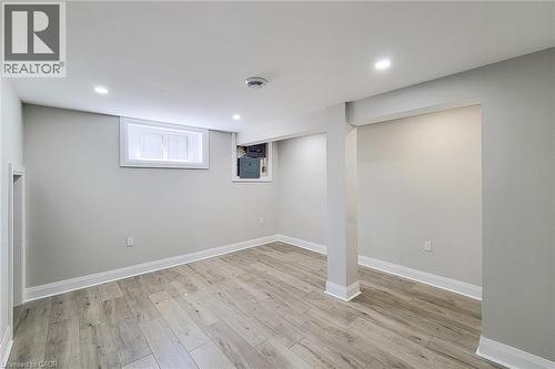 Finished lower-level room featuring wood-finish flooring, recessed lighting, a white framed window, and light-toned walls - 103 East 45Th Street, Hamilton, ON - Indoor