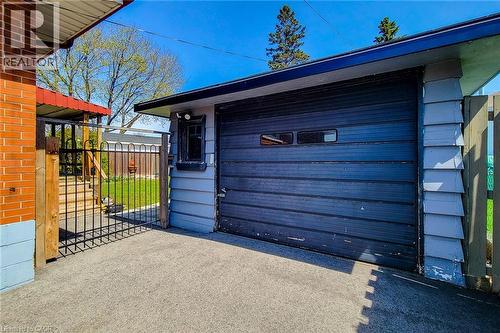 Attached single-car garage featuring a dark panel door with rectangular window inserts - 103 East 45Th Street, Hamilton, ON - Outdoor With Exterior