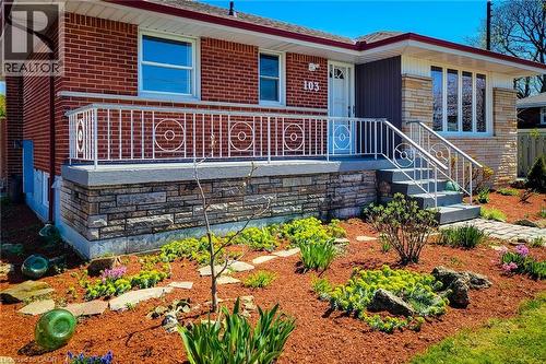 Brick and stone-clad exterior with a white railing porch and front steps - 103 East 45Th Street, Hamilton, ON - Outdoor
