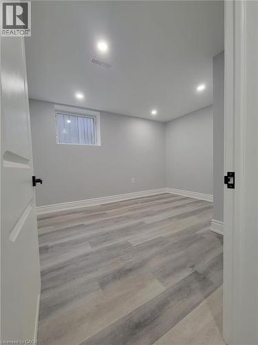 Room featuring light gray walls, wood-finish flooring, recessed lighting, and a white trim package - 168 Garside Avenue N, Hamilton, ON - Indoor