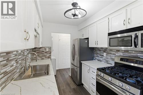 Modern kitchen featuring white cabinetry, stone-finish countertops, and stainless steel appliances - 341 Rexford Drive, Hamilton, ON - Indoor Photo Showing Kitchen With Stainless Steel Kitchen With Upgraded Kitchen