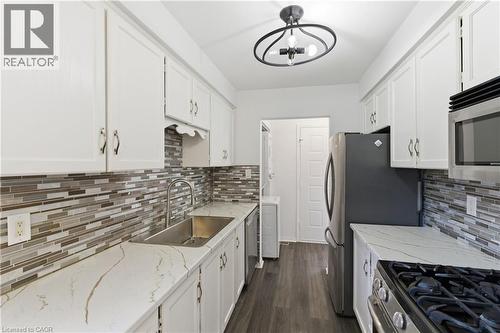 Kitchen featuring white cabinetry, a mosaic tile backsplash, and light-toned countertops with veining - 341 Rexford Drive, Hamilton, ON - Indoor Photo Showing Kitchen With Upgraded Kitchen