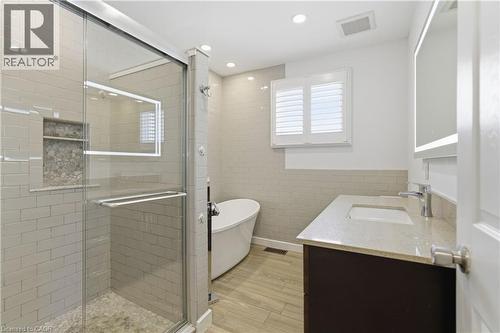 Shower enclosure with glass door, subway tile walls, and a recessed niche - 341 Rexford Drive, Hamilton, ON - Indoor Photo Showing Bathroom