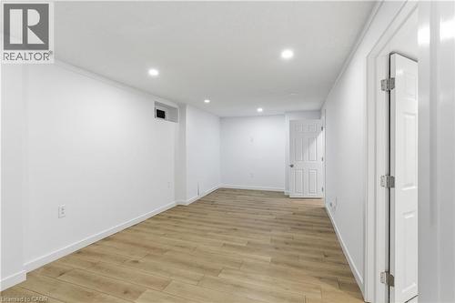 Spacious interior featuring wood-finish flooring, white walls, and recessed lighting - 341 Rexford Drive, Hamilton, ON - Indoor Photo Showing Other Room