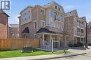 Multi-story townhouse featuring a brick and stucco exterior, multiple balconies with metal railings, a covered front porch with white columns, gabled rooflines, and a private fenced yard with green la - 9 Rabbit Run Way, Brampton, ON  - Outdoor With Facade 