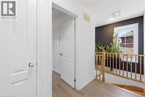 Hallway with light wood-finish flooring, white panel doors, and a wood railing - 9 Rabbit Run Way, Brampton, ON - Indoor Photo Showing Other Room