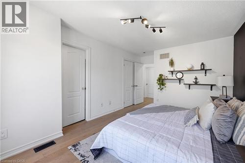 Bedroom featuring light wood-finish flooring, white walls, and a contrasting dark accent wall - 9 Rabbit Run Way, Brampton, ON - Indoor Photo Showing Bedroom