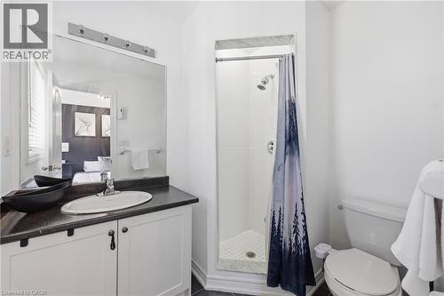 Compact bathroom featuring a white vanity with dark countertop, an inset sink, and a framed mirror with bar lighting - 9 Rabbit Run Way, Brampton, ON - Indoor Photo Showing Bathroom