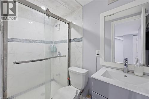 Enclosed shower with a sliding glass door, white tile surround, and an accent mosaic tile band - 9 Rabbit Run Way, Brampton, ON - Indoor Photo Showing Bathroom