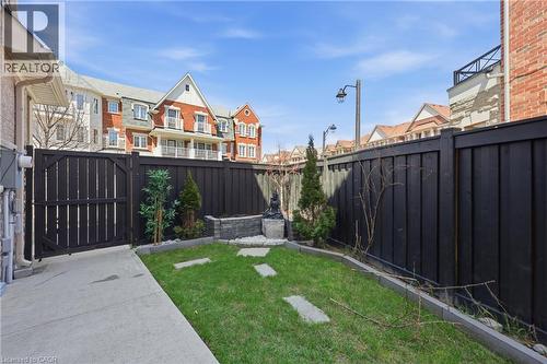 Private outdoor space featuring a dark-stained wood fence, a small lawn area with stepping stones, and a concrete patio - 9 Rabbit Run Way, Brampton, ON - Outdoor