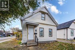 Unit 1A Entrance; White siding exterior with a dark shingle roof and contrasting trim - 