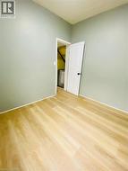 Unit 1A Bedroom; Room featuring light wood-finish flooring, light green painted walls, and white trim - 