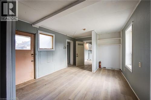 Bedroom 1 featuring wood-finish flooring, light gray wall paneling, and an exposed beam ceiling detail - 1 Rathgar Street, London, ON - Indoor Photo Showing Other Room