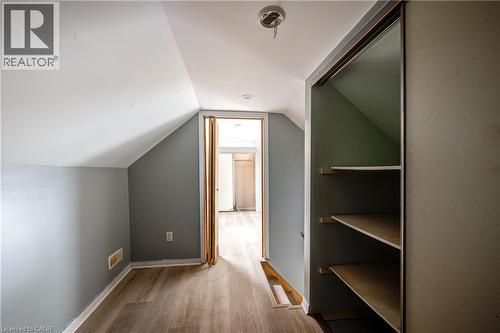 Loft space featuring sloped ceilings, light wood-finish flooring, a neutral wall color, and a built-in closet with shelving - 1 Rathgar Street, London, ON - Indoor Photo Showing Other Room