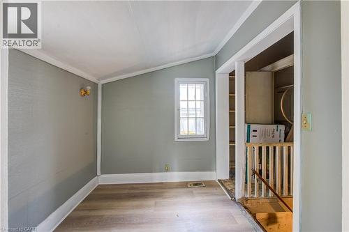 Access to basement stair hallway featuring wood-finish flooring, a single window with grilles, and light gray wall finishes - 1 Rathgar Street, London, ON - Indoor Photo Showing Other Room