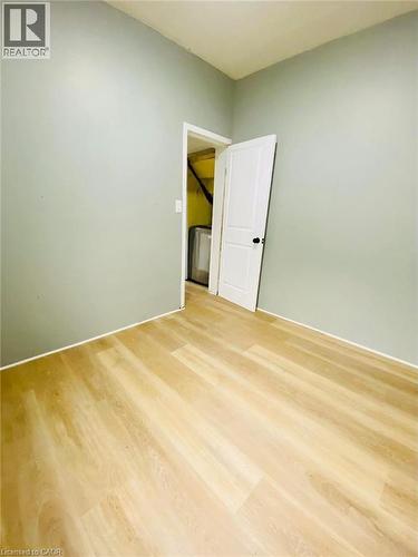 Unit 1A Bedroom; Room featuring light wood-finish flooring, light green painted walls, and white trim - 1 Rathgar Street, London, ON - Indoor Photo Showing Other Room