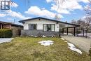 Exterior featuring a white facade with dark trim, stone veneer detailing, a covered carport, and a concrete driveway - 85 Ranchdale Drive, Hamilton, ON  - Outdoor 