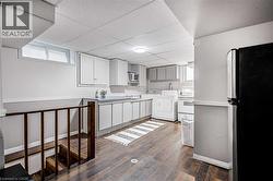 Lower level utility space featuring wood-finish flooring and a drop ceiling - 