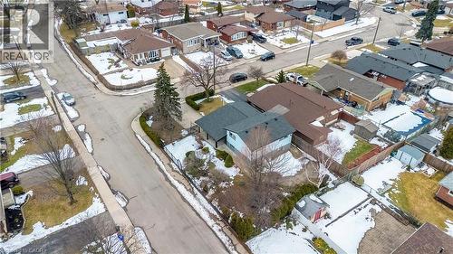 Corner lot property featuring a light blue exterior, dark roof, and a mature evergreen tree in the front yard - 85 Ranchdale Drive, Hamilton, ON - 