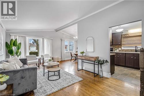 Bright living space featuring hardwood flooring, vaulted ceiling, and large front-facing window - 85 Ranchdale Drive, Hamilton, ON 