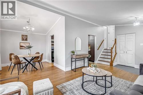 Open-concept living area featuring hardwood flooring, light gray wall tones, and white crown molding - 85 Ranchdale Drive, Hamilton, ON 