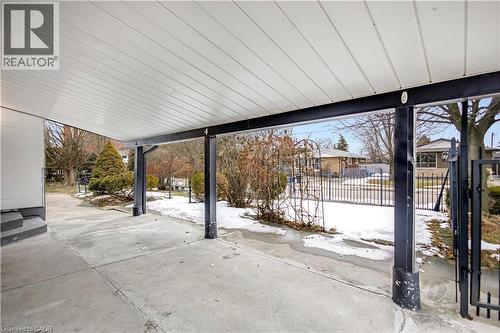 Covered concrete patio with a white paneled ceiling and black support beams - 85 Ranchdale Drive, Hamilton, ON - Outdoor