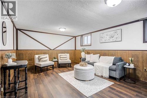 Finished lower level featuring wood-finish flooring, paneled walls, white ceilings, and recessed windows - 85 Ranchdale Drive, Hamilton, ON 