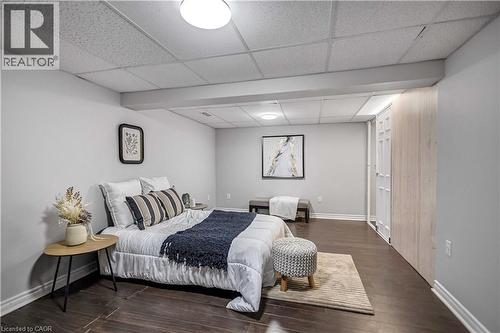 Spacious room featuring wood-finish flooring, light grey painted walls, and a dropped ceiling with integrated lighting - 85 Ranchdale Drive, Hamilton, ON 