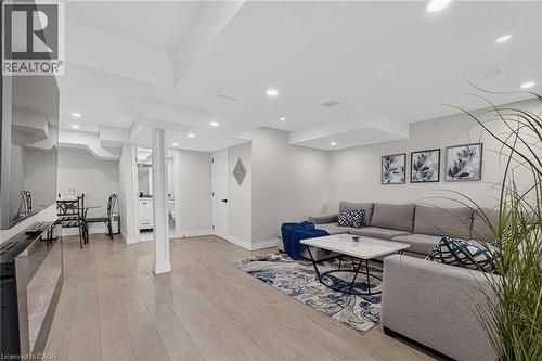 Open-concept lower level featuring wood-finish flooring, recessed lighting, and a white interior door - 79 Holbrook Crescent, Cambridge, ON - Indoor