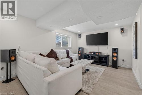 Brightly lit living area featuring recessed lighting, a window with blinds, light wood-finish flooring, and white painted walls - 79 Holbrook Crescent, Cambridge, ON - Indoor