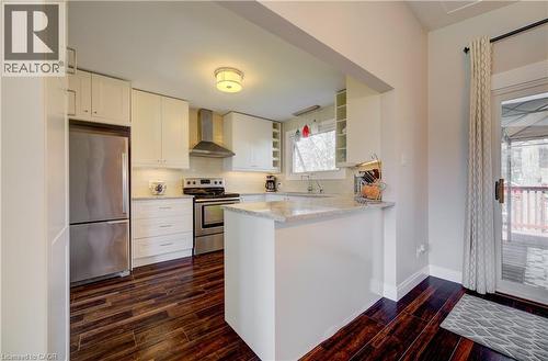 Bright kitchen featuring white cabinetry, stainless steel appliances, dark wood-finish flooring, and light-toned countertops - 172 Rennie Drive, Kitchener, ON - Indoor Photo Showing Kitchen