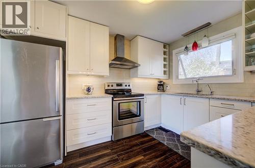 Kitchen featuring white cabinetry, stainless steel appliances, granite countertops, wood-finish flooring, and a subway tile backsplash - 172 Rennie Drive, Kitchener, ON - Indoor Photo Showing Kitchen With Upgraded Kitchen