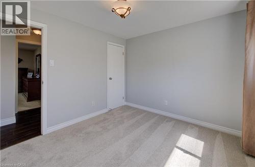 Neutral-toned room featuring light-colored carpeting, a standard white door, and white baseboards - 172 Rennie Drive, Kitchener, ON - Indoor Photo Showing Other Room