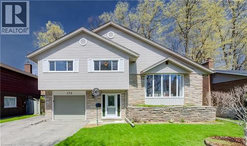 Split-level residence featuring light-toned horizontal siding and stone veneer accents - 172 Rennie Drive, Kitchener, ON - Outdoor