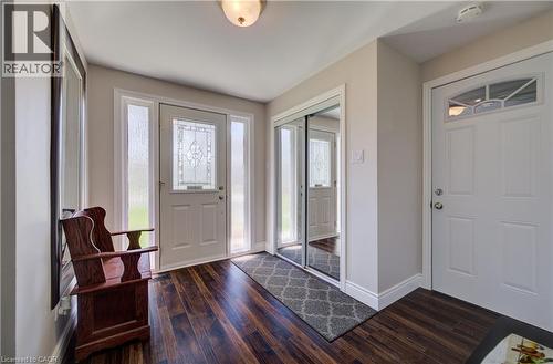 Front entry featuring a decorative glass door with sidelights, wood-finish flooring, and a mirrored sliding closet - 172 Rennie Drive, Kitchener, ON - Indoor Photo Showing Other Room
