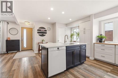 Kitchen island featuring a white countertop, integrated sink with a gooseneck faucet, and contrasting dark cabinetry - 30 Darlington Drive, Hamilton, ON - Indoor Photo Showing Kitchen