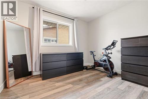 Room featuring light-toned wood-finish flooring, neutral wall paint, and a sliding window with light-colored drapes - 30 Darlington Drive, Hamilton, ON - Indoor Photo Showing Gym Room