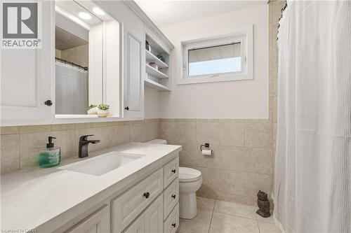 Bathroom vanity featuring a rectangular integrated sink, matte black faucet, and white shaker-style cabinetry with black hardware - 30 Darlington Drive, Hamilton, ON - Indoor Photo Showing Bathroom