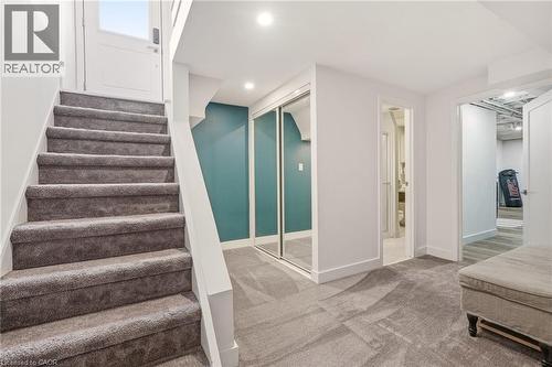 Carpeted staircase with white risers and handrail, leading to an upper-level door - 30 Darlington Drive, Hamilton, ON - Indoor Photo Showing Other Room