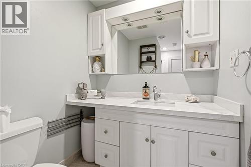 Vanity featuring a white countertop with integrated sink, chrome faucet, and white cabinetry - 30 Darlington Drive, Hamilton, ON - Indoor Photo Showing Bathroom