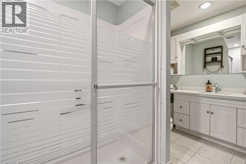 Walk-in shower with frosted glass enclosure, featuring a white vanity with paneled cabinetry, a rectangular undermount sink, and a large mirror - 30 Darlington Drive, Hamilton, ON - Indoor Photo Showing Bathroom